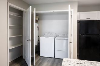 a kitchen with a washer and dryer and a refrigerator