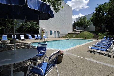 A pool area with blue chairs and a table.