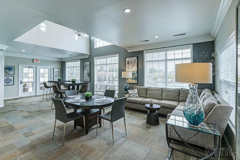 A well-lit living room with a dining table and chairs.