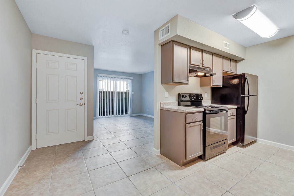 A kitchen with a refrigerator, oven, and microwave.