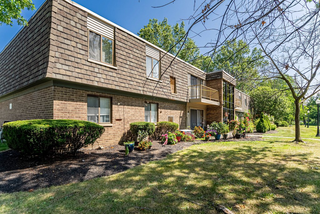 A row of houses with green lawns in front.