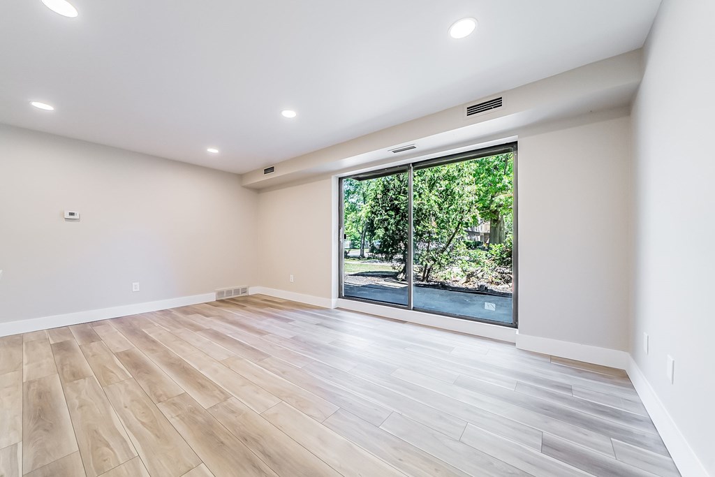 A room with a large window and wooden flooring.