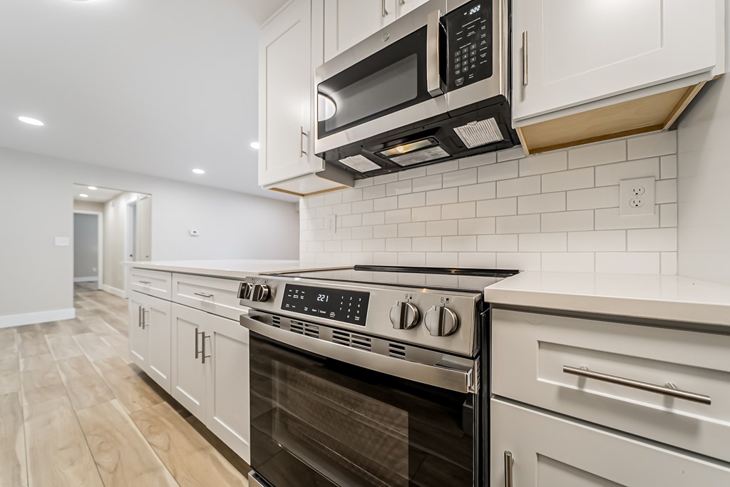 A modern kitchen with a stainless steel oven and microwave.