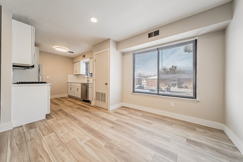 A kitchen area with a refrigerator, sink, and cabinets.
