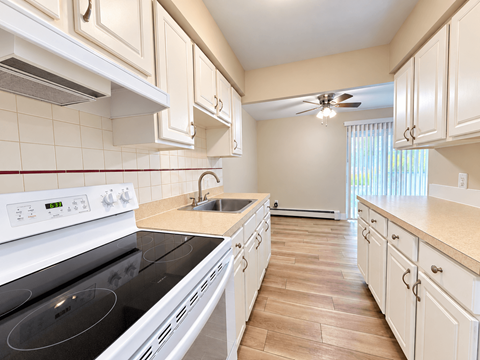 A kitchen with white appliances and cabinets.