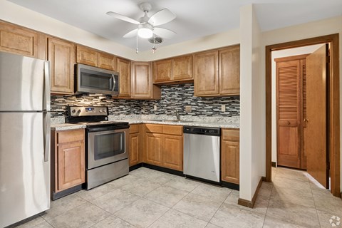 A kitchen with wooden cabinets and a white refrigerator.