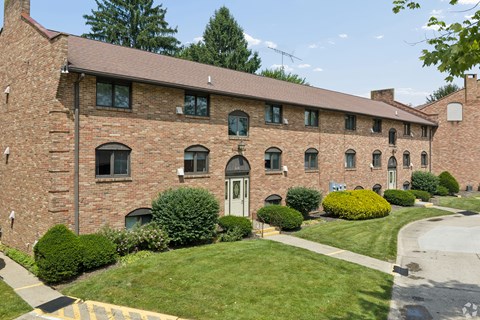 A large red brick building with a white door and windows.