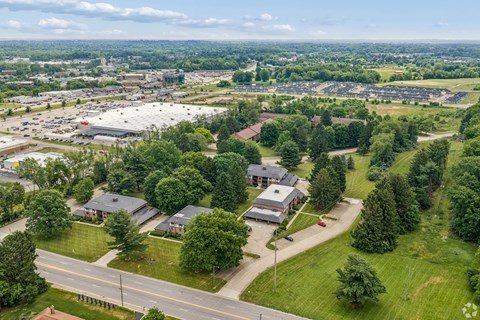 A bird's eye view of a suburban area with houses and a road.
