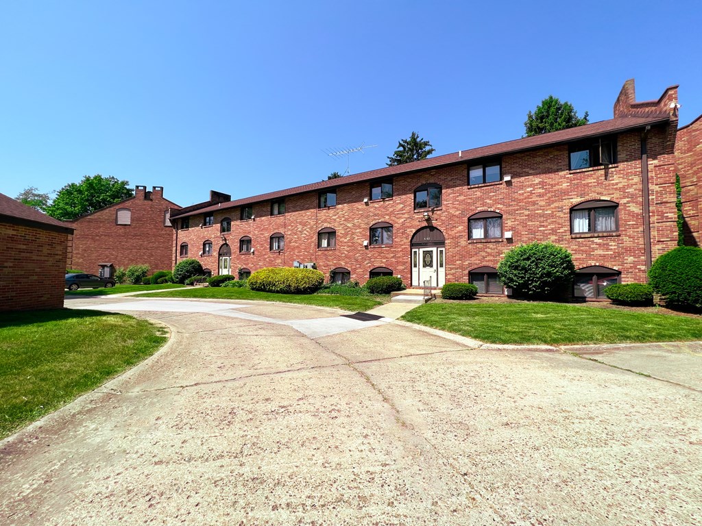 a large brick building with a driveway in front of it