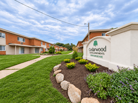 Cedarwood Apartments is a residential complex with a well-maintained garden in front.
