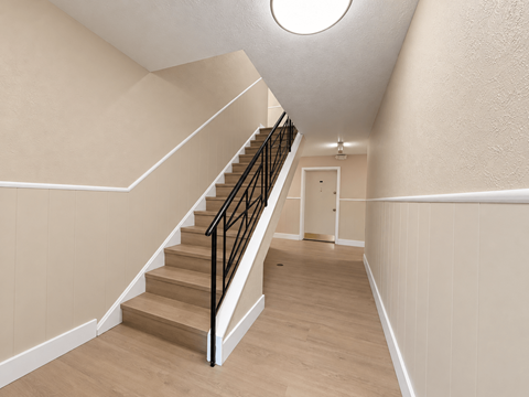 A staircase with a black railing and wooden steps.