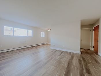 A room with wooden flooring and white walls.