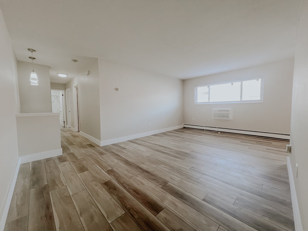A room with wooden flooring and a window.