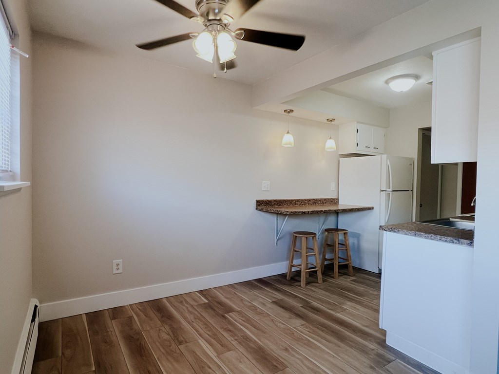 A kitchen with a table and bar stools.