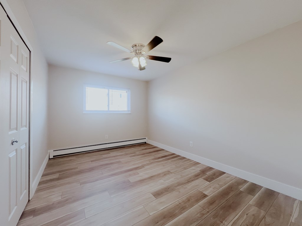 A room with a ceiling fan and a window.
