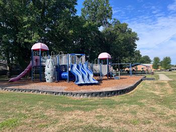A playground with a blue slide and a red slide.