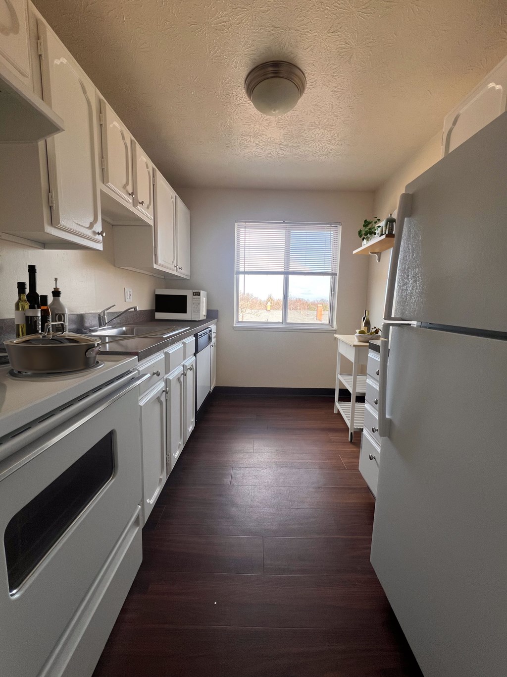 a kitchen with white cabinets and a window