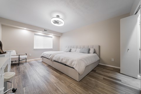 A bedroom with a large bed and a window with blinds at Huntington Green Apartments, University Heights, OH