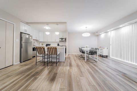 A kitchen with a dining table and chairs.