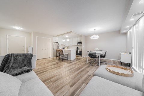 A modern living room with a grey sofa and a wooden floor.