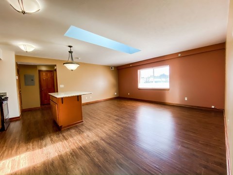 an empty living room with wood floors and a table
