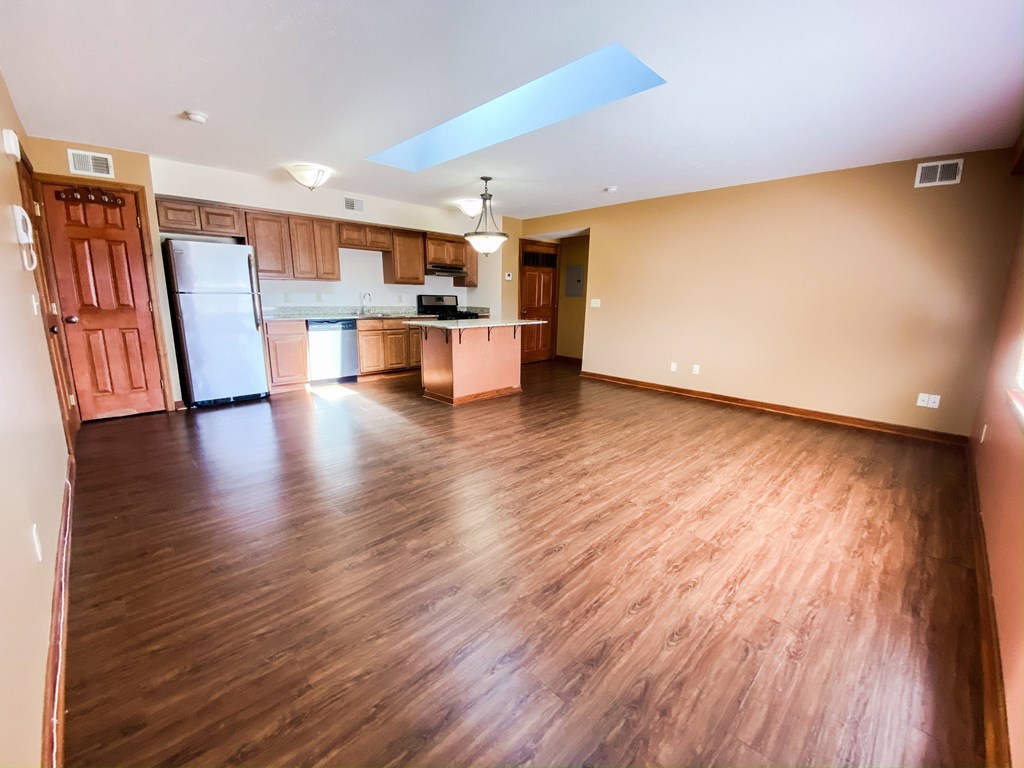 an empty living room and kitchen with wood flooring at Hallwood Manor Apartments, Mentor, OH, 44060