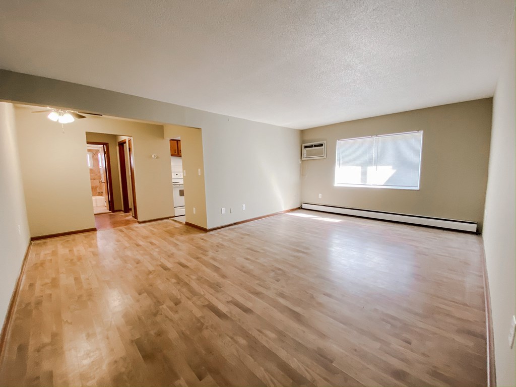 an empty living room with wood floors and a window at Hallwood Manor Apartments, Mentor