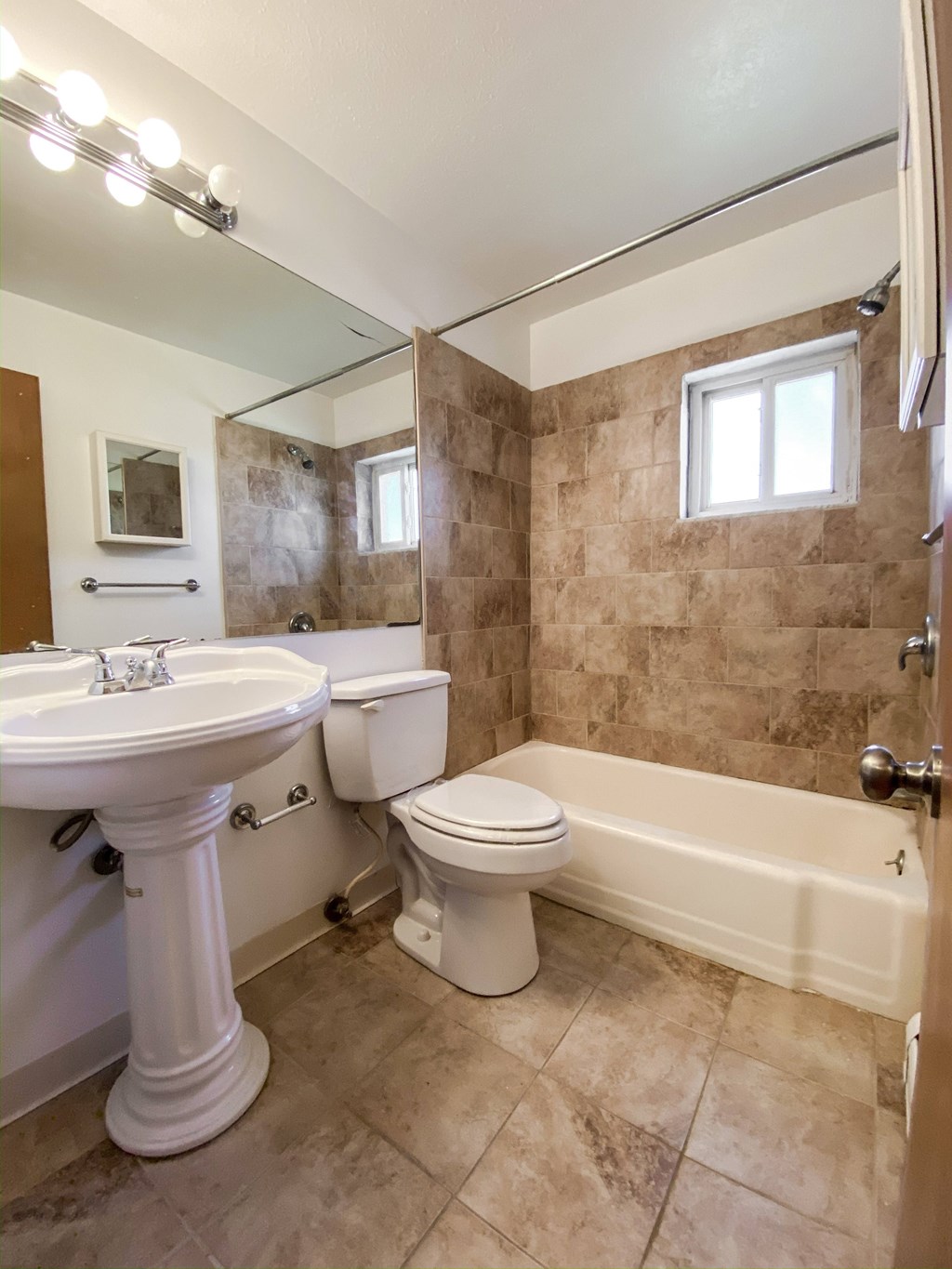 a bathroom with a toilet and a sink and a bath tub at Hallwood Manor Apartments, Mentor, OH