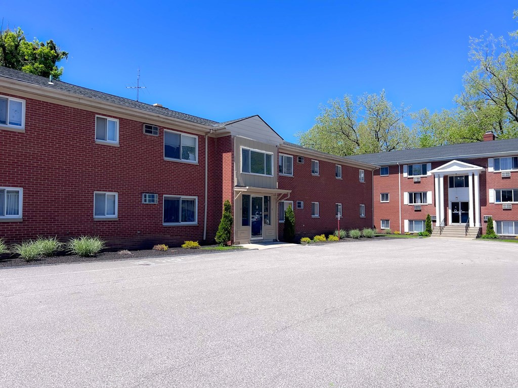 A large red brick building with a parking lot in front. at Hallwood Manor Apartments, Mentor, 44060