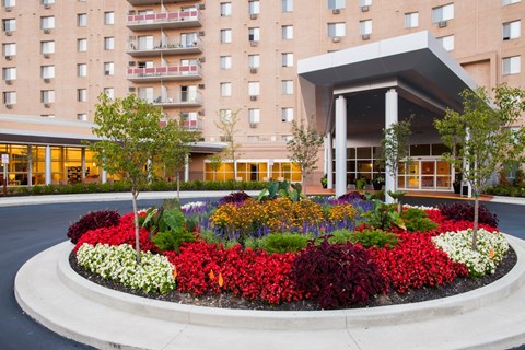 A flower bed in front of a building entrance at Hummingbird Pointe & The Gardens, Parma, OH 44129