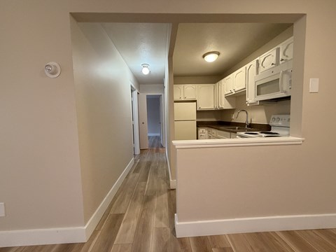 A kitchen with white cabinets and appliances.