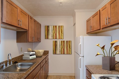 A kitchen with brown cabinets and a painting on the wall.