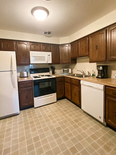 a kitchen with white appliances and wooden cabinets