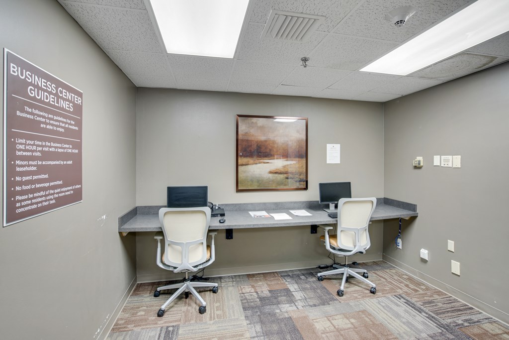 A room with a poster on the wall and two chairs in front of a desk at Independence Place Apartments, Parma Heights