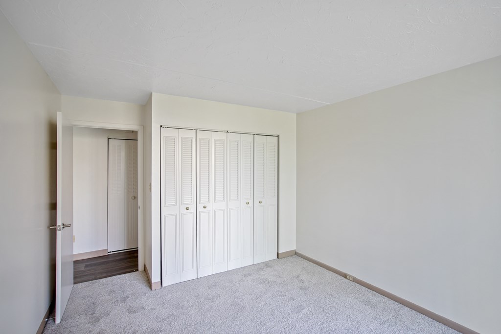 A room with white cupboards and a grey carpet at Independence Place Apartments, Parma Heights