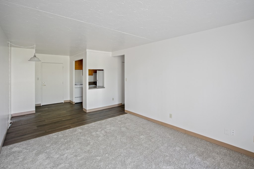 A large empty room with a carpeted floor and white walls at Independence Place Apartments, Parma Heights, Ohio