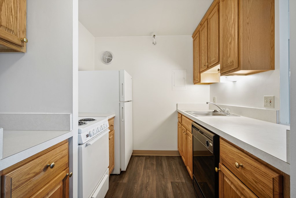 A kitchen with wooden cabinets and white appliances at Independence Place Apartments, Ohio