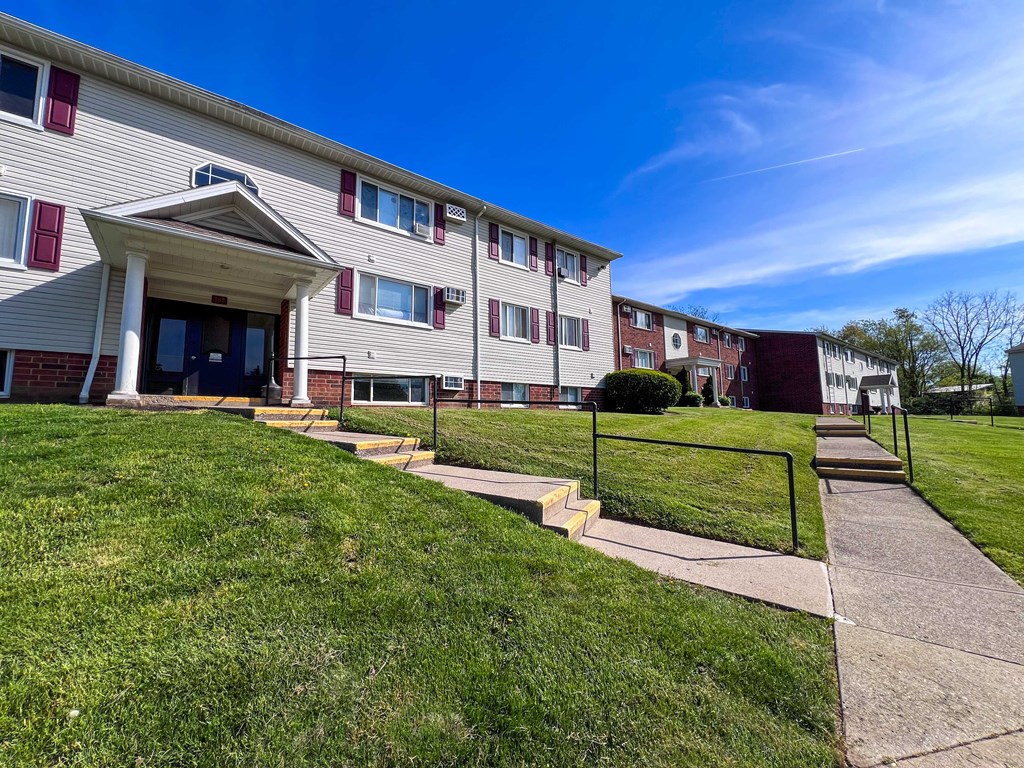 apartment building with sidewalk and stairs in front of it