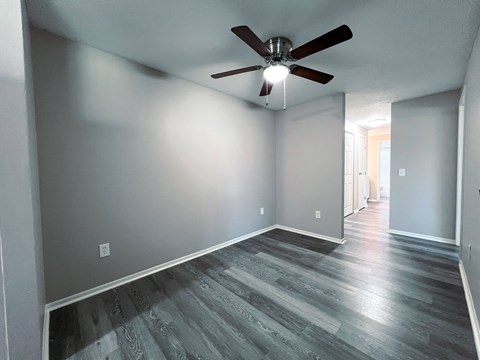 a living room with gray walls and a ceiling fan