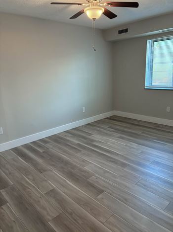 A room with a ceiling fan and light fixture.