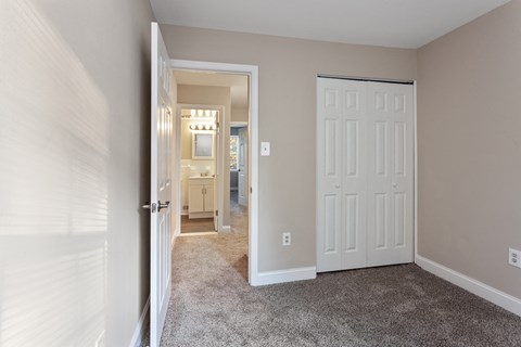 a bedroom with two closets and a door to a bathroom