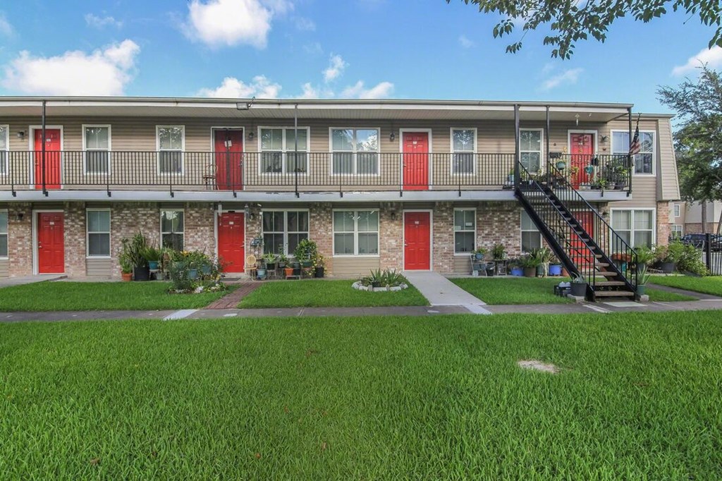an exterior view of a building with red doors and balconies