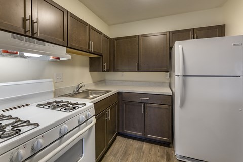 a kitchen with white appliances and wooden cabinets and a refrigerator