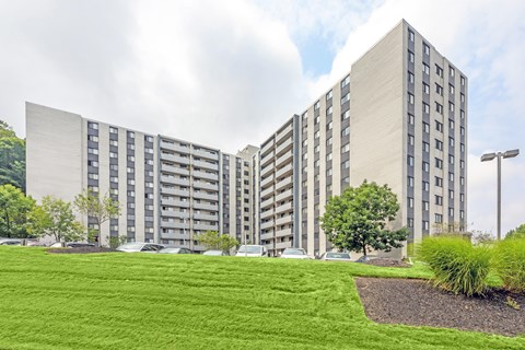 A large building with a green lawn in front.