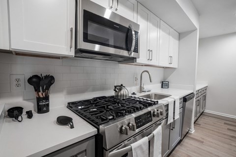 a kitchen with white cabinets and a stove and a microwave