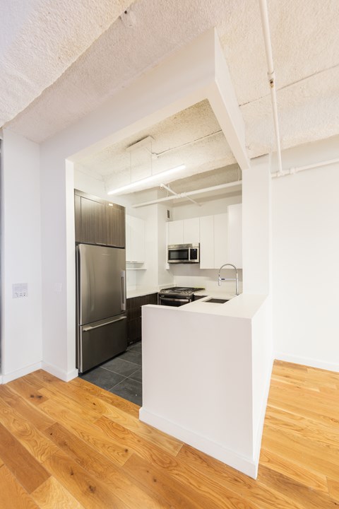 a kitchen with a island and a stainless steel refrigerator