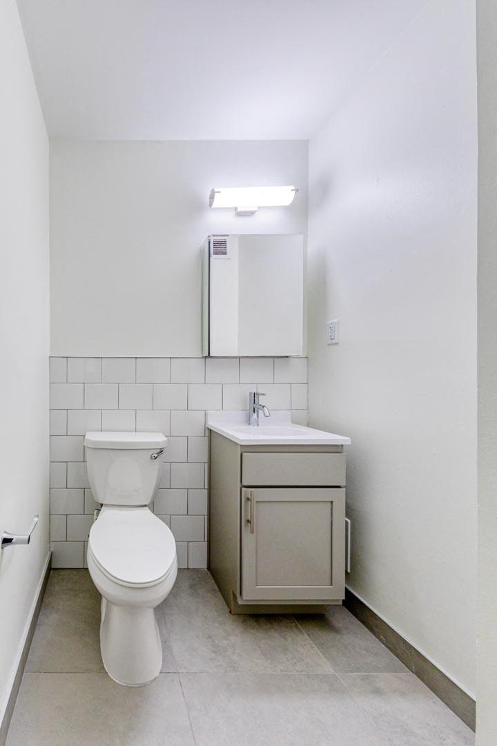 a bathroom with a toilet sink and mirror