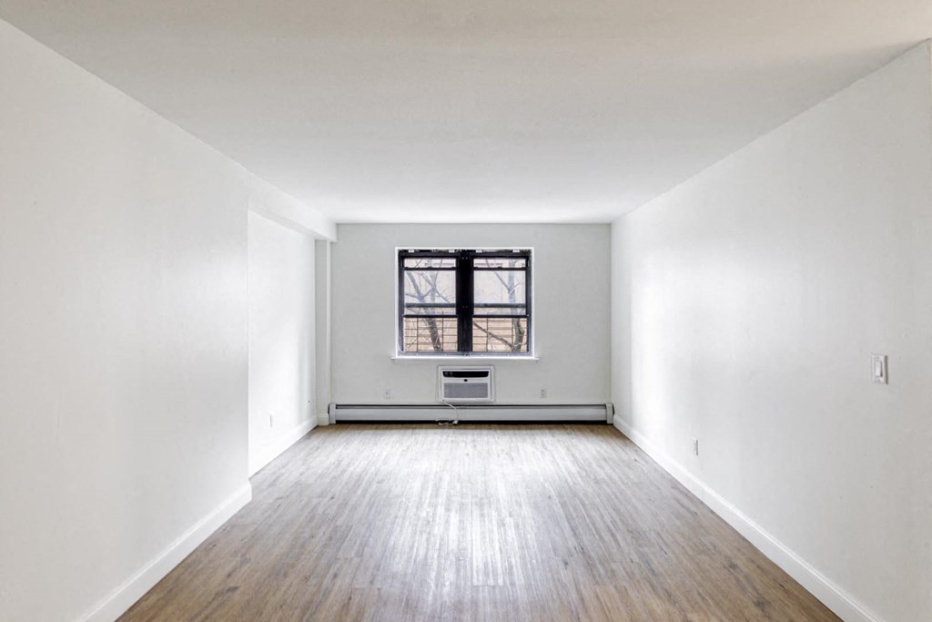 an empty room with white walls and a window