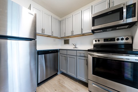A kitchen with a stainless steel refrigerator and oven.
