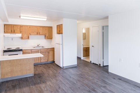 A kitchen with white appliances and wooden cabinets.